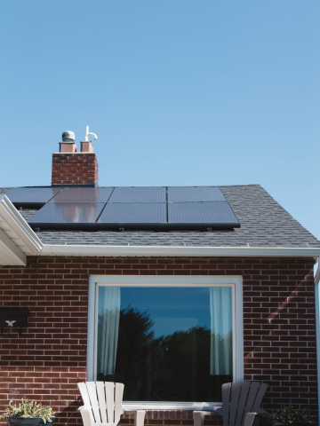 Framifrån visning av ett hem med solpaneler på taket.
